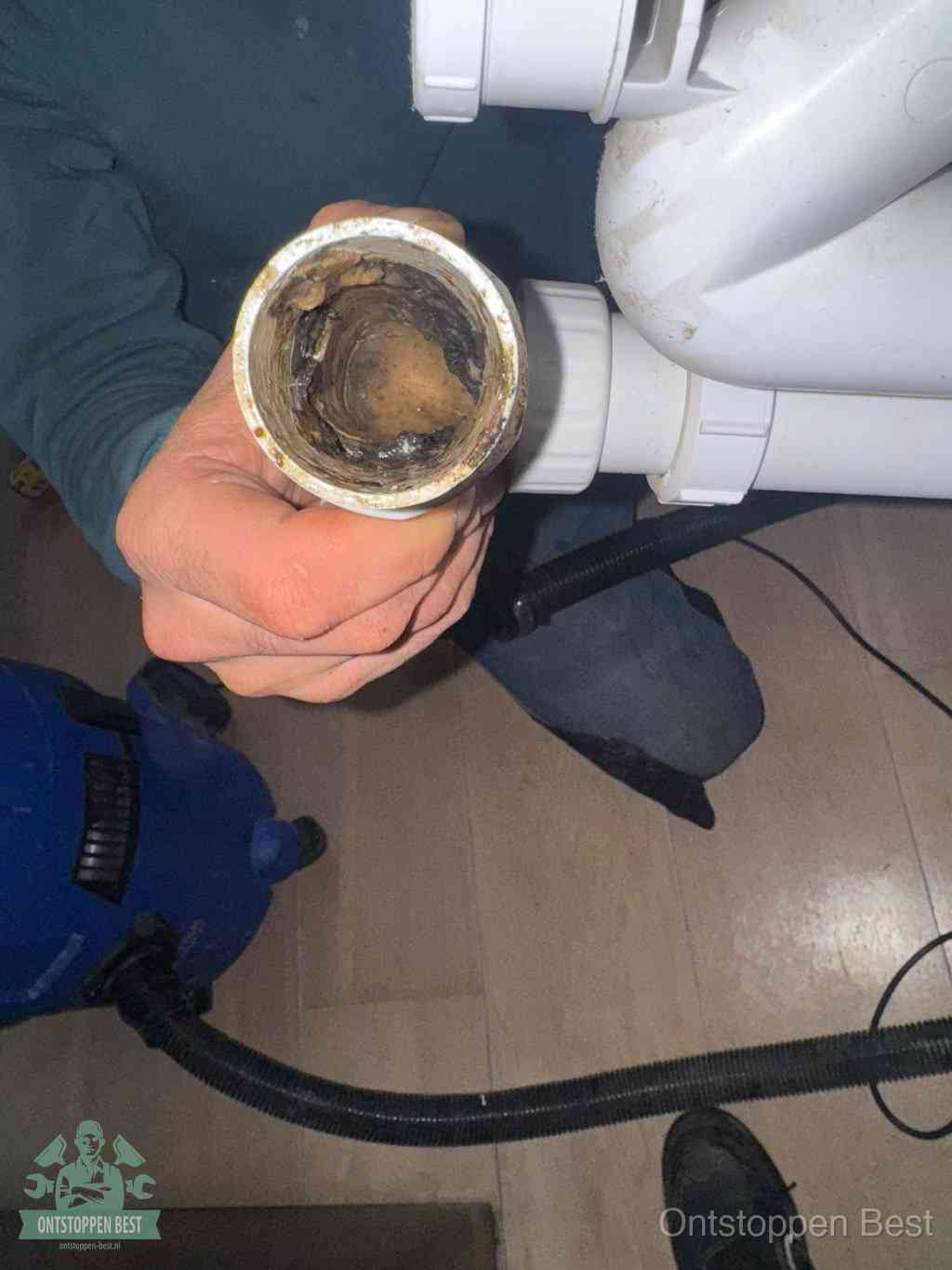 Een losgekoppeld afvoerbuisstuk dat van binnen volledig is dichtgeslibd, het gevolg van een verstopping te lang laten zitten in Best
