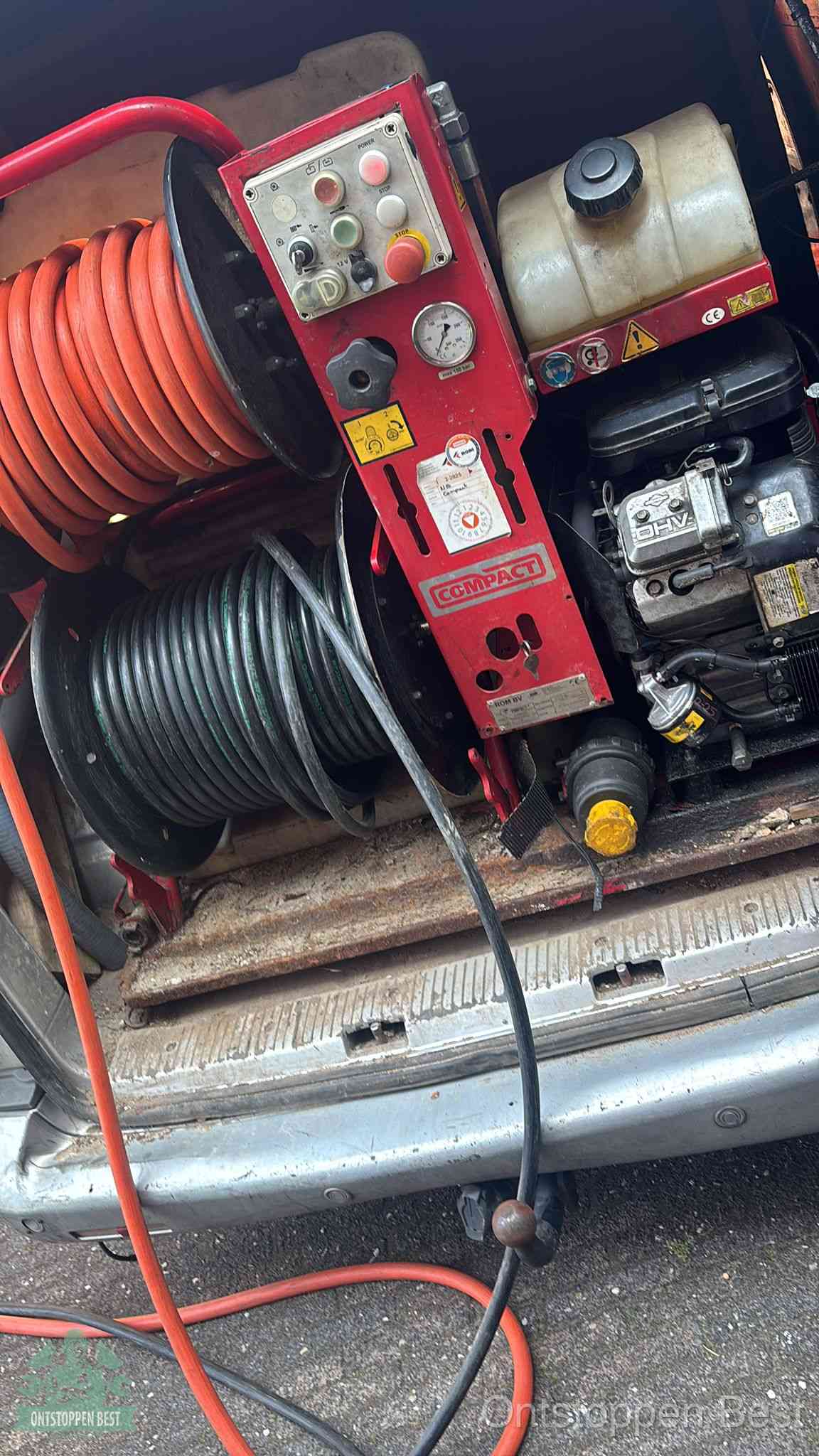 Een rood hogedruk-rioolreinigingstoestel in de laadbak van de bedrijfsbus, apparatuur voor een hardnekkige afvoerverstopping in Best