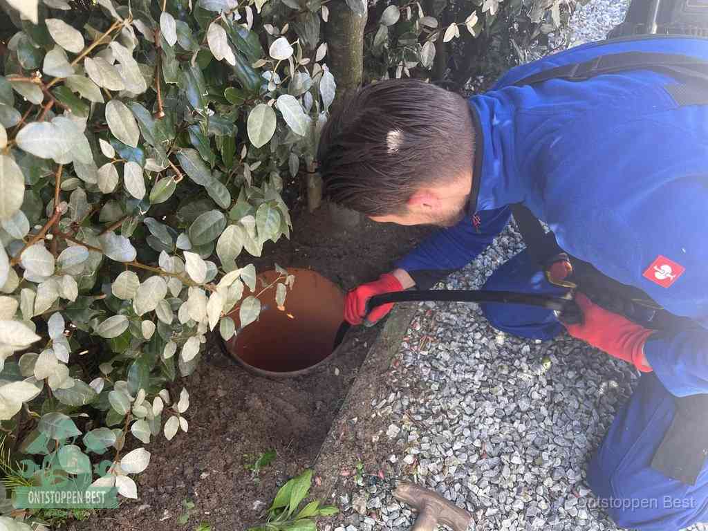 Monteur reinigt een rioolput met een slang, periodieke rioolreiniging in Best