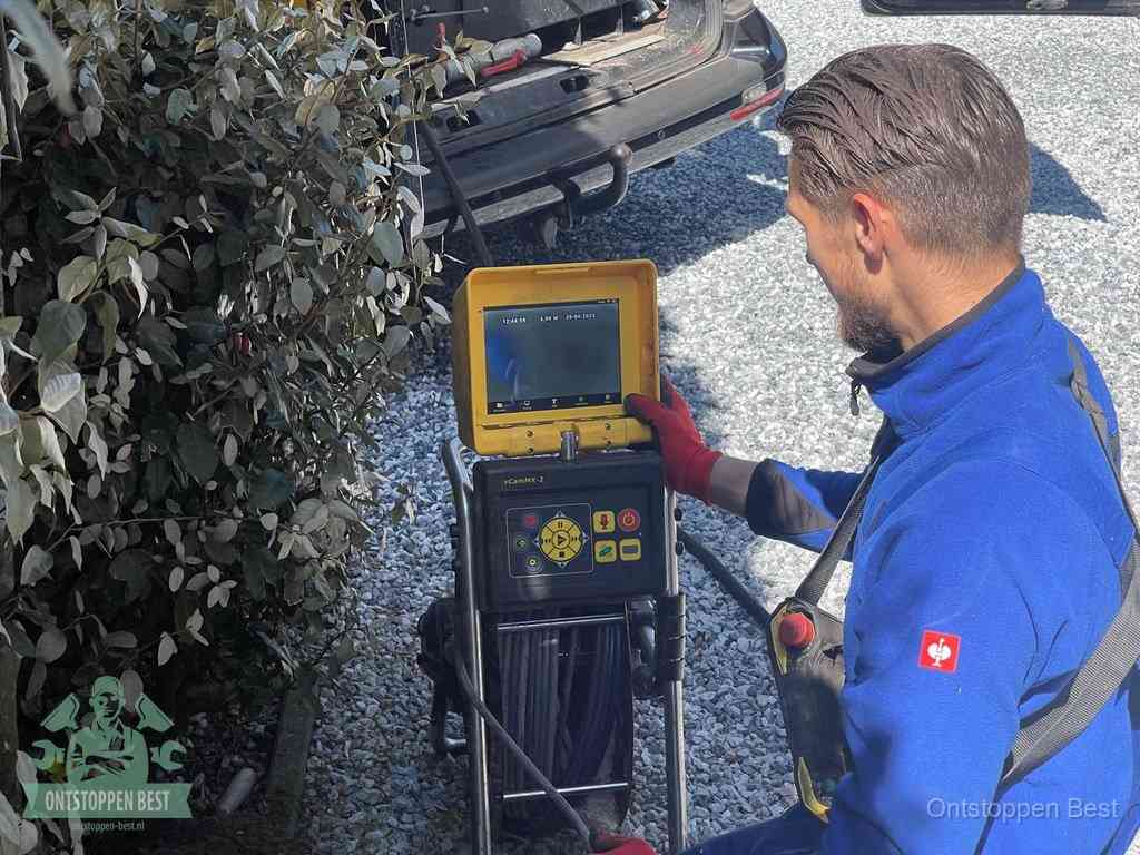 Monteur bedient een rioolinspectiecamera met monitor voor rioolinspectie in Best