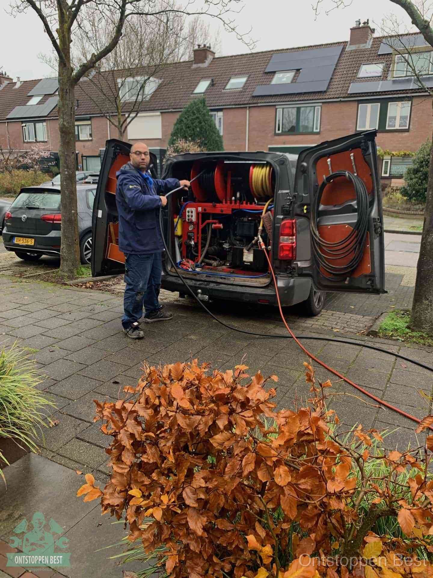Monteur met rioolreinigingsbus levert rioolservice in de wijk in Best