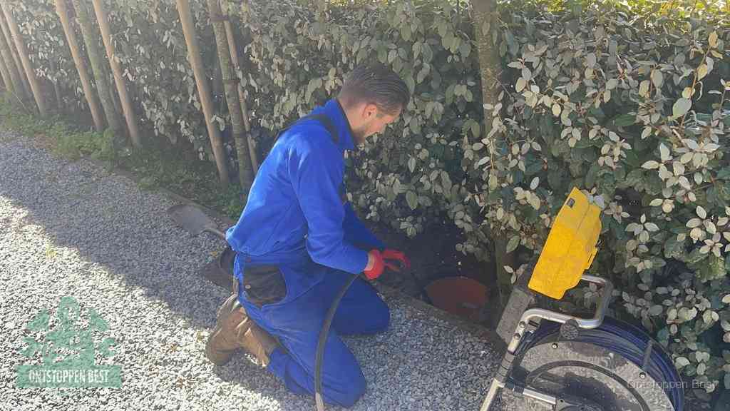 Monteur aan het werk bij een rioolput, de werkwijze voor riool ontstoppen in Best