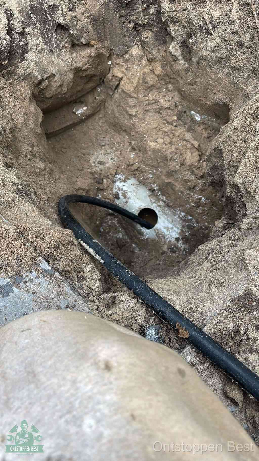 Uitgegraven rioolbuis in de grond, hulp om zelf het riool te ontstoppen in Best